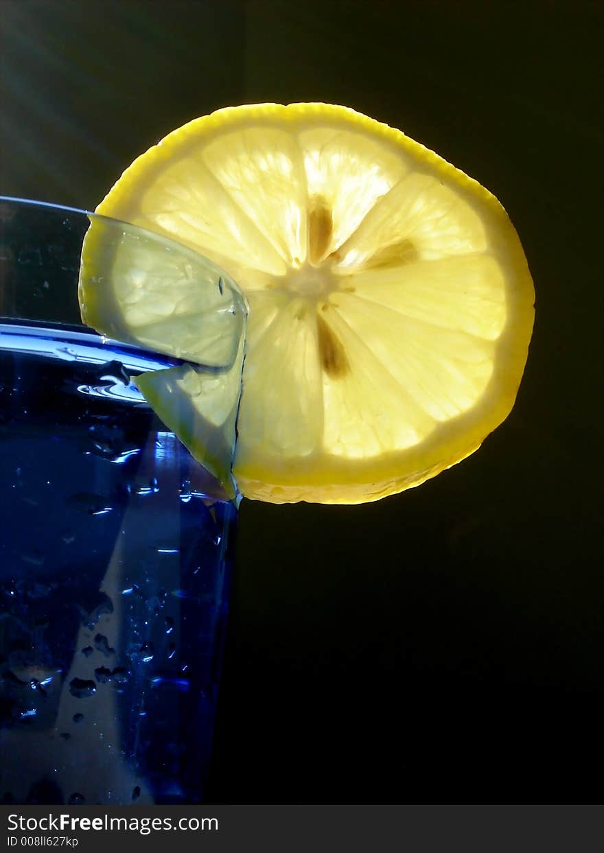 Cocktail drink decorated with lemon and served in a blue glass. Cocktail drink decorated with lemon and served in a blue glass