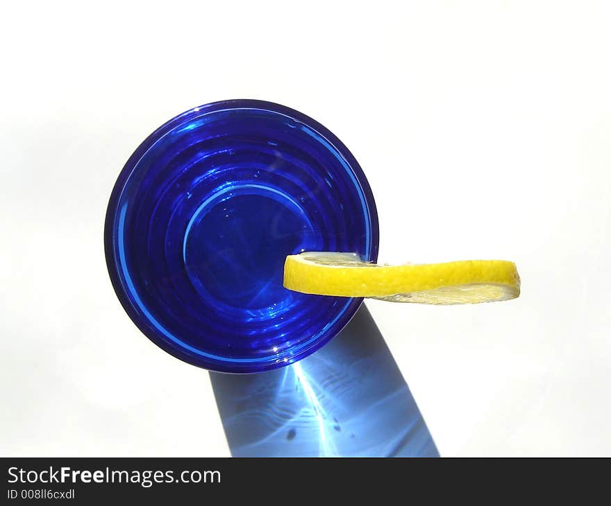 Cocktail drink decorated with lemon and served in a blue glass. Cocktail drink decorated with lemon and served in a blue glass