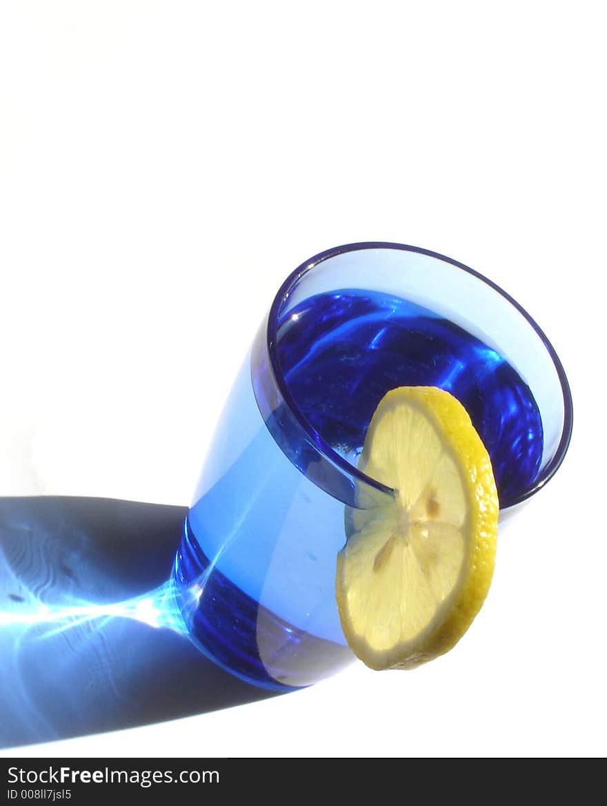 Cocktail drink decorated with lemon and served in a blue glass. Cocktail drink decorated with lemon and served in a blue glass