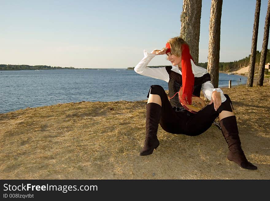 Pirate girl waiting for her ship on a beach