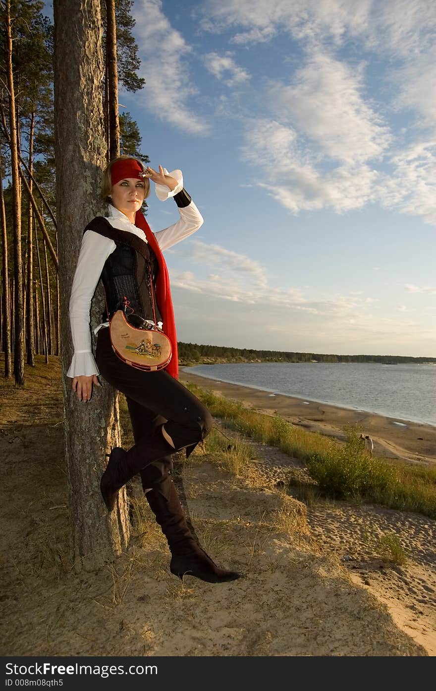 Pirate girl waiting for her ship on a beach