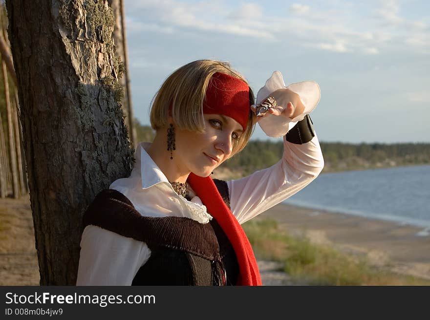 Pirate girl waiting for her ship on a beach