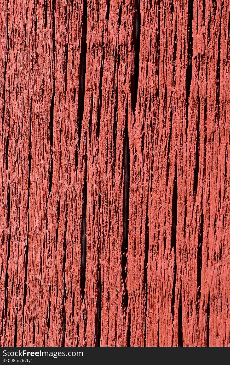 Bright red paint on weathered barn board.