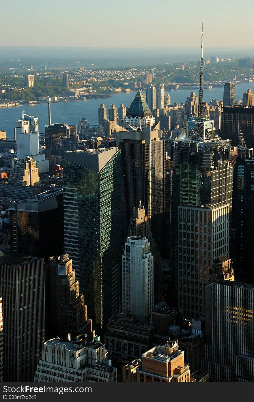 Aerial view of a several urban office buildings.  There is a river in the background.  It is early in the morning.  The scene is lit by a low warm sunlight. Aerial view of a several urban office buildings.  There is a river in the background.  It is early in the morning.  The scene is lit by a low warm sunlight.