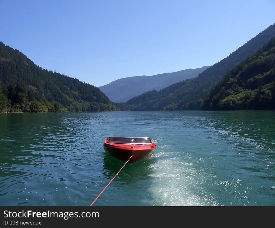 A red boat getting toed through the mountains