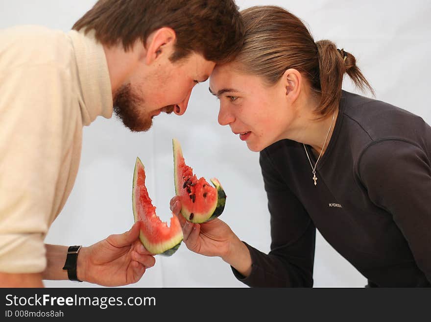 Man and the woman eat a watermelon on white. Man and the woman eat a watermelon on white