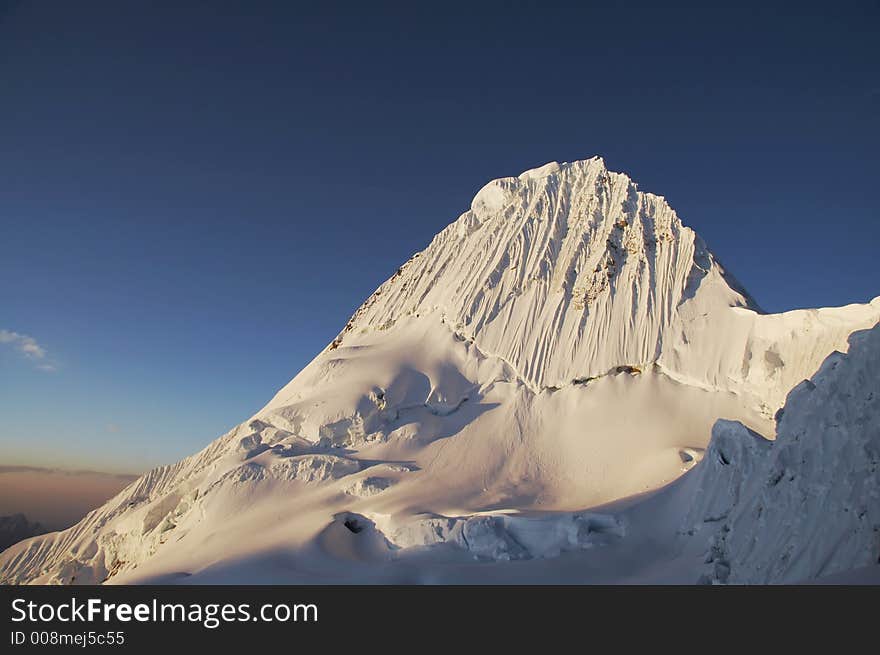 Peak Alpamayo on the sunset in Cordilleras. Peak Alpamayo on the sunset in Cordilleras