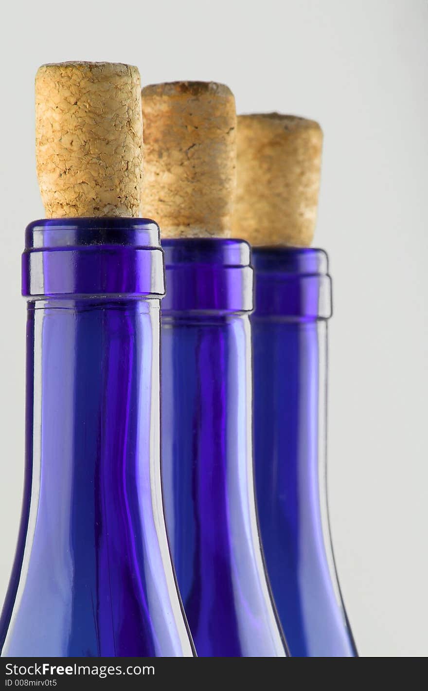 Three blue bottles with corks isolated on white (close up)