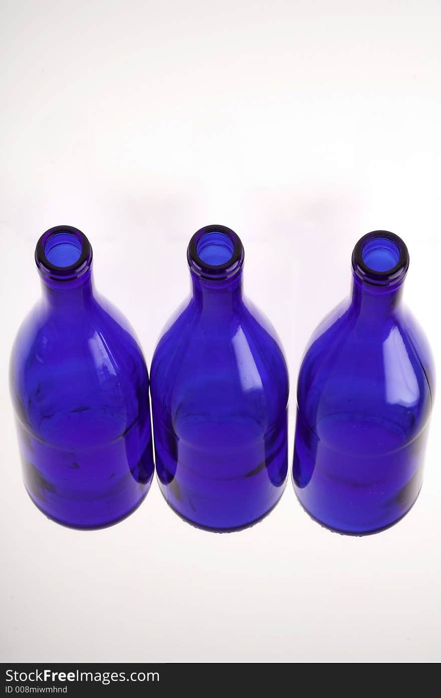 Three empty blue bottles isolated on white (close up)