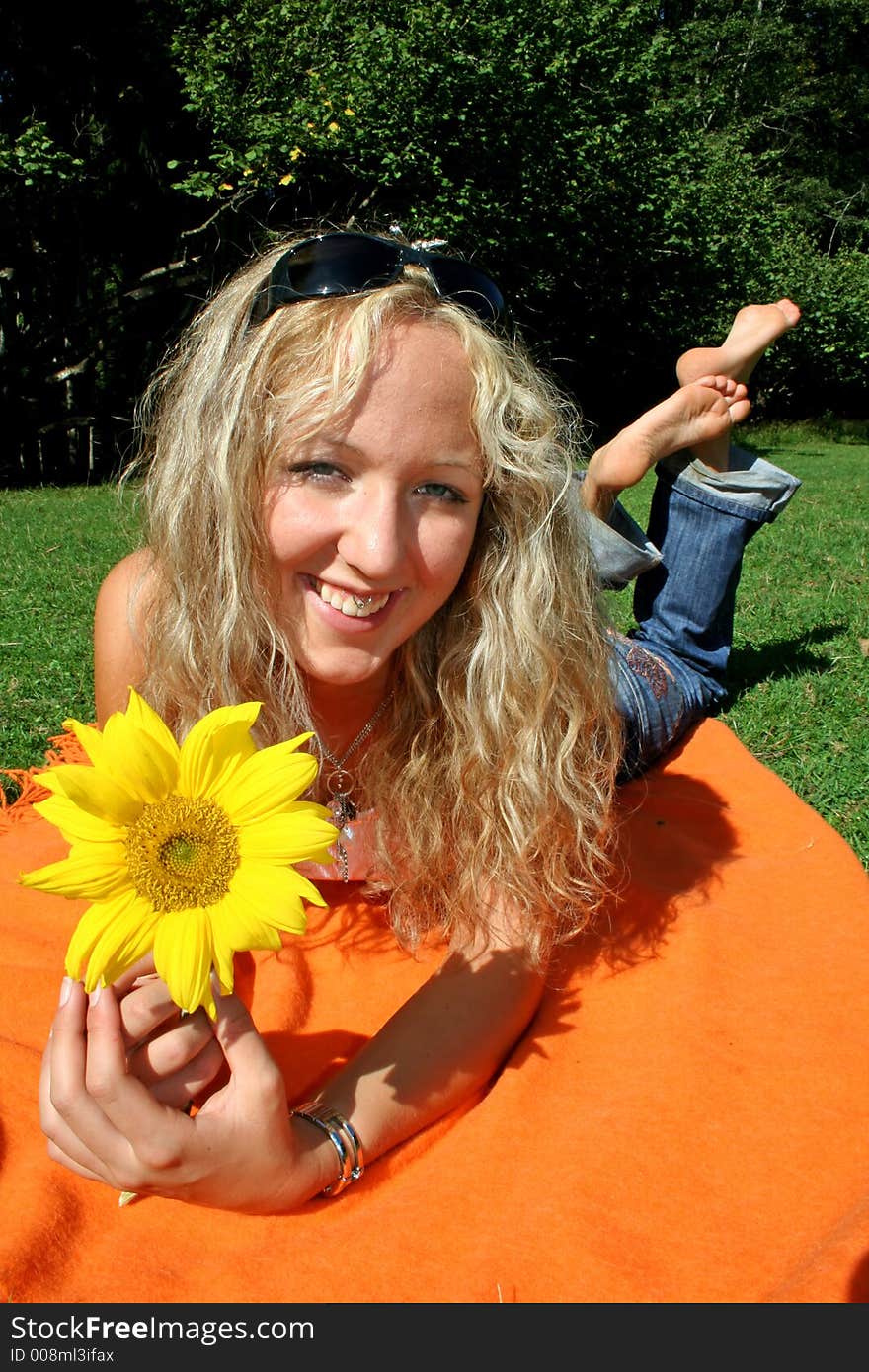 Portrait of beautiful blonde teenager with sunflower in park. Portrait of beautiful blonde teenager with sunflower in park