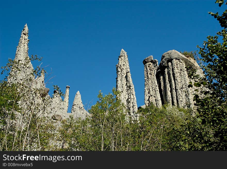 The Demoiselles Coiffées (approximate translation: young ladies with fancy hair or nice hat) is a striking set of narrowly-tapered rock columns standing along the top of a crumbly rock ridge. Each column is topped with a large rock balanced neatly on the tip, helping to protect the demoiselle from complete erosion. The Demoiselles Coiffées (approximate translation: young ladies with fancy hair or nice hat) is a striking set of narrowly-tapered rock columns standing along the top of a crumbly rock ridge. Each column is topped with a large rock balanced neatly on the tip, helping to protect the demoiselle from complete erosion.