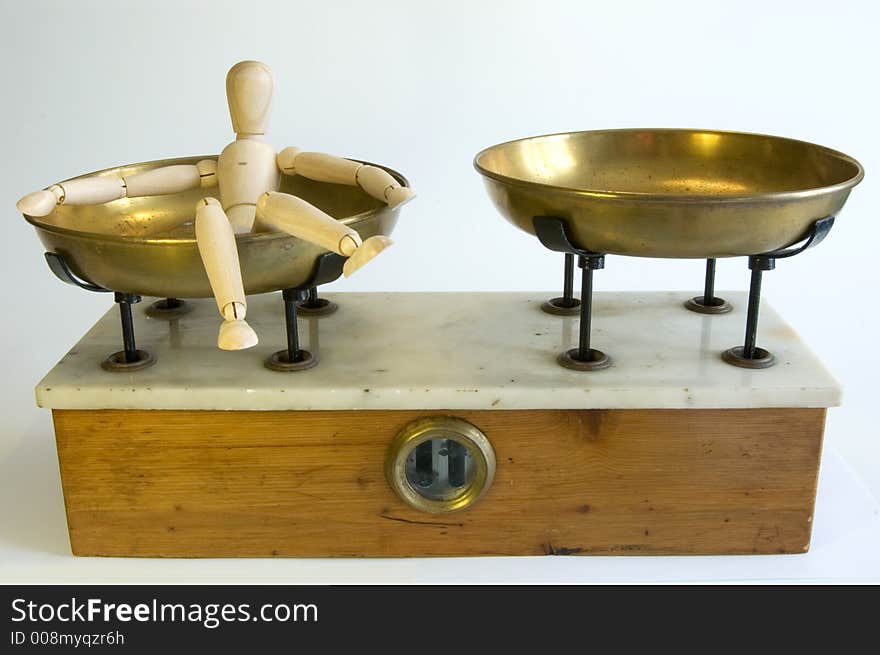 A wooden mannequine laying on a balance plate. A wooden mannequine laying on a balance plate