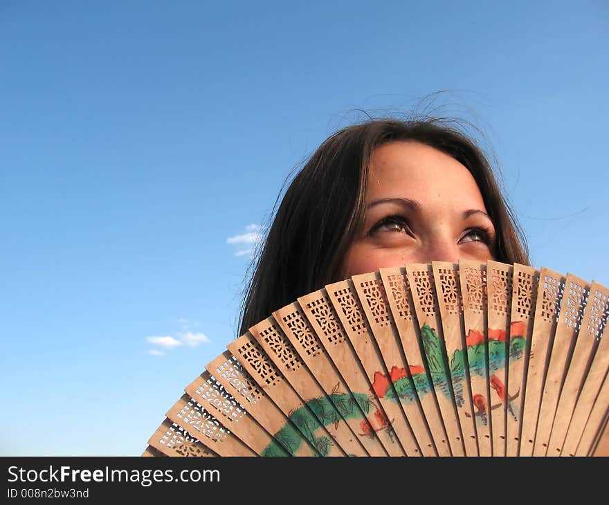 Attractive girl hidden by a fan