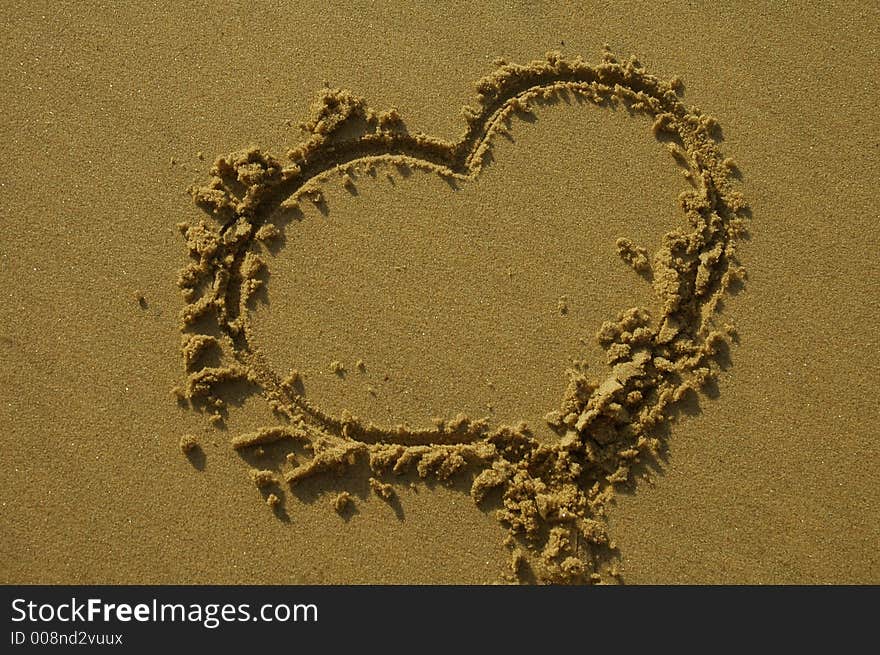 Love heart written in sand