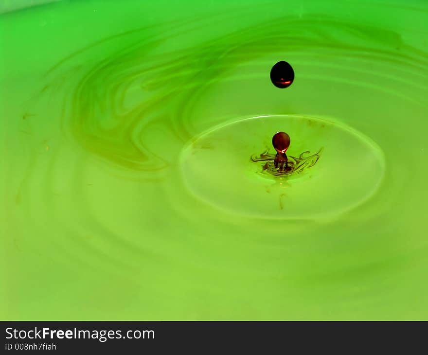 Drop of iodine in a green plastic water bowl. Drop of iodine in a green plastic water bowl