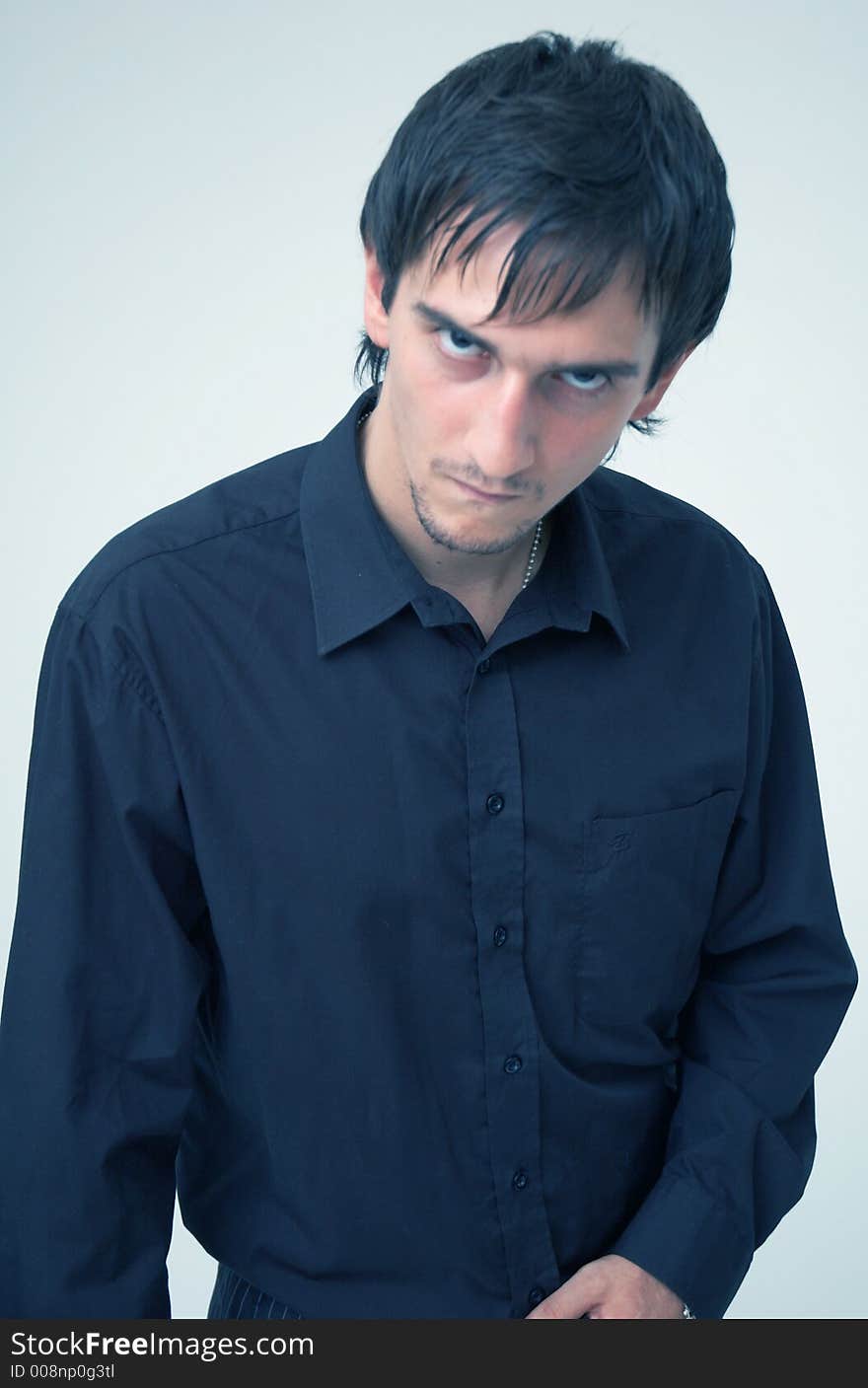 Portrait of a young boy wearing a black shirt posing in a studio; isolated on orange. Portrait of a young boy wearing a black shirt posing in a studio; isolated on orange