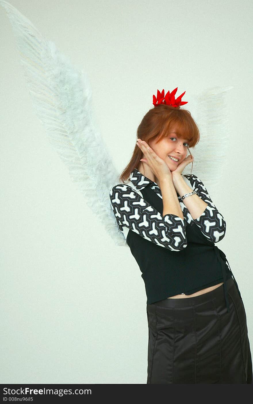 Beautiful girl with angel wings and a bunch of red chilli peppers as a acessory for the hair. Beautiful girl with angel wings and a bunch of red chilli peppers as a acessory for the hair