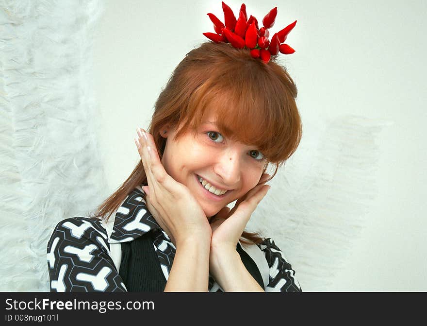 Portrait of a beautiful girl with angel wings and a bunch of red chilli peppers as a acessory for the hair. Portrait of a beautiful girl with angel wings and a bunch of red chilli peppers as a acessory for the hair