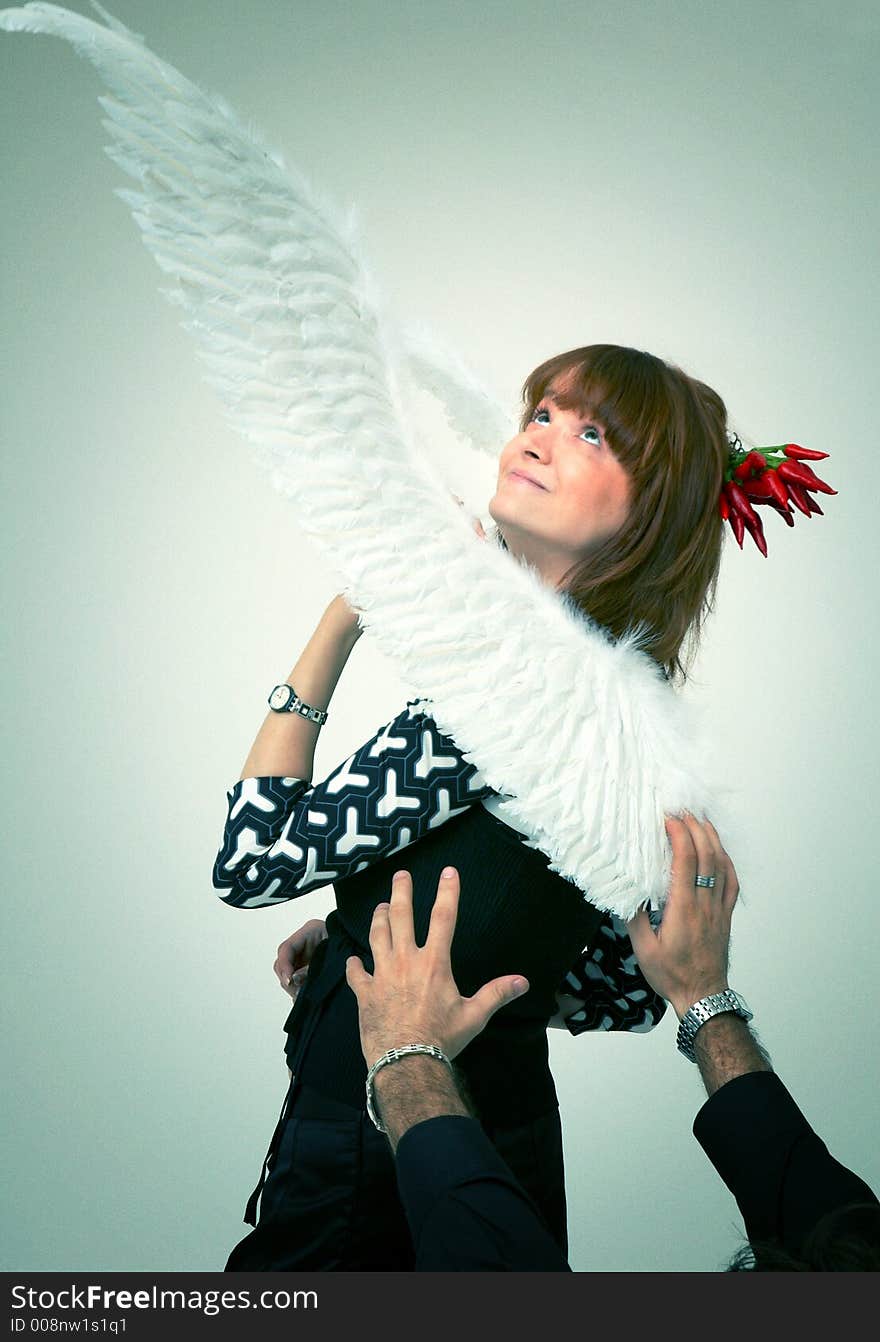 Man hands reaching a beautiful redhead girl with angel wings. Man hands reaching a beautiful redhead girl with angel wings