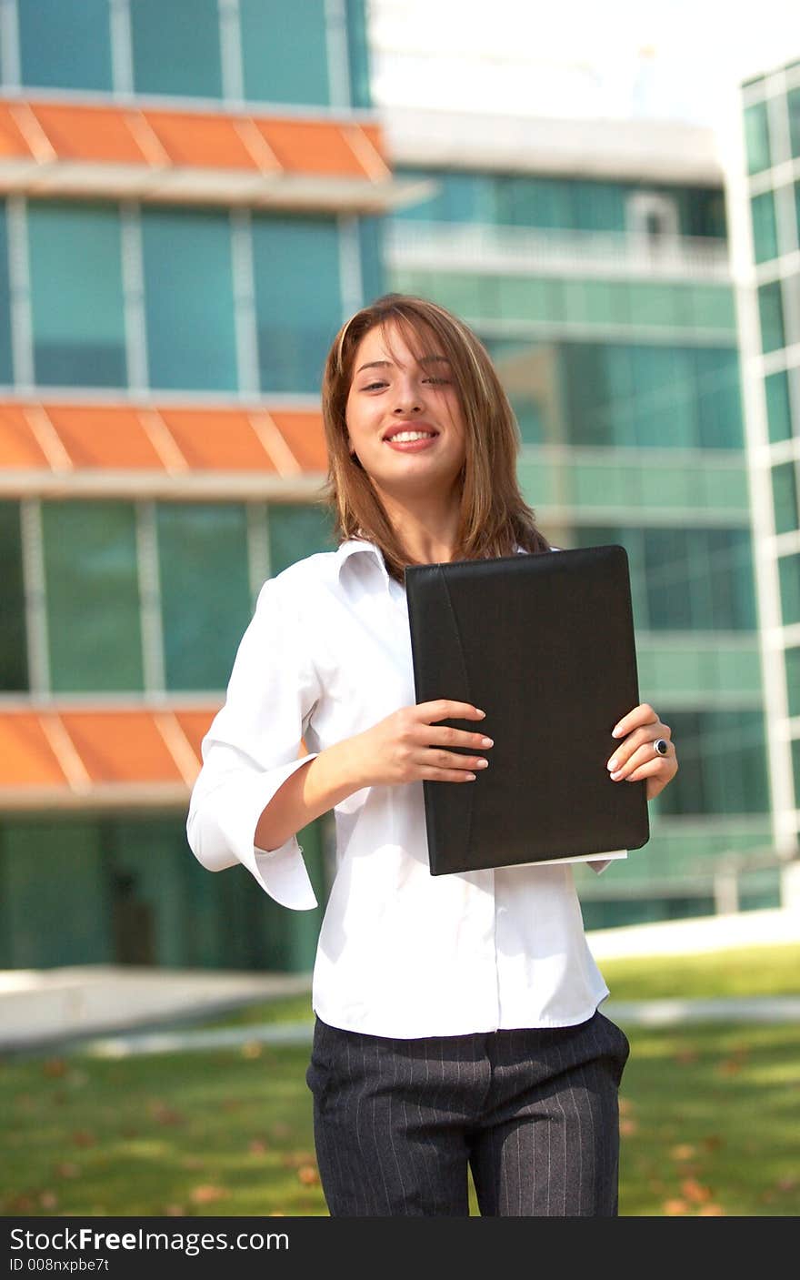 Portrait of a beautiful young girl with casual clothes holding an agenda in her hands, smiling and looking relaxed. Portrait of a beautiful young girl with casual clothes holding an agenda in her hands, smiling and looking relaxed