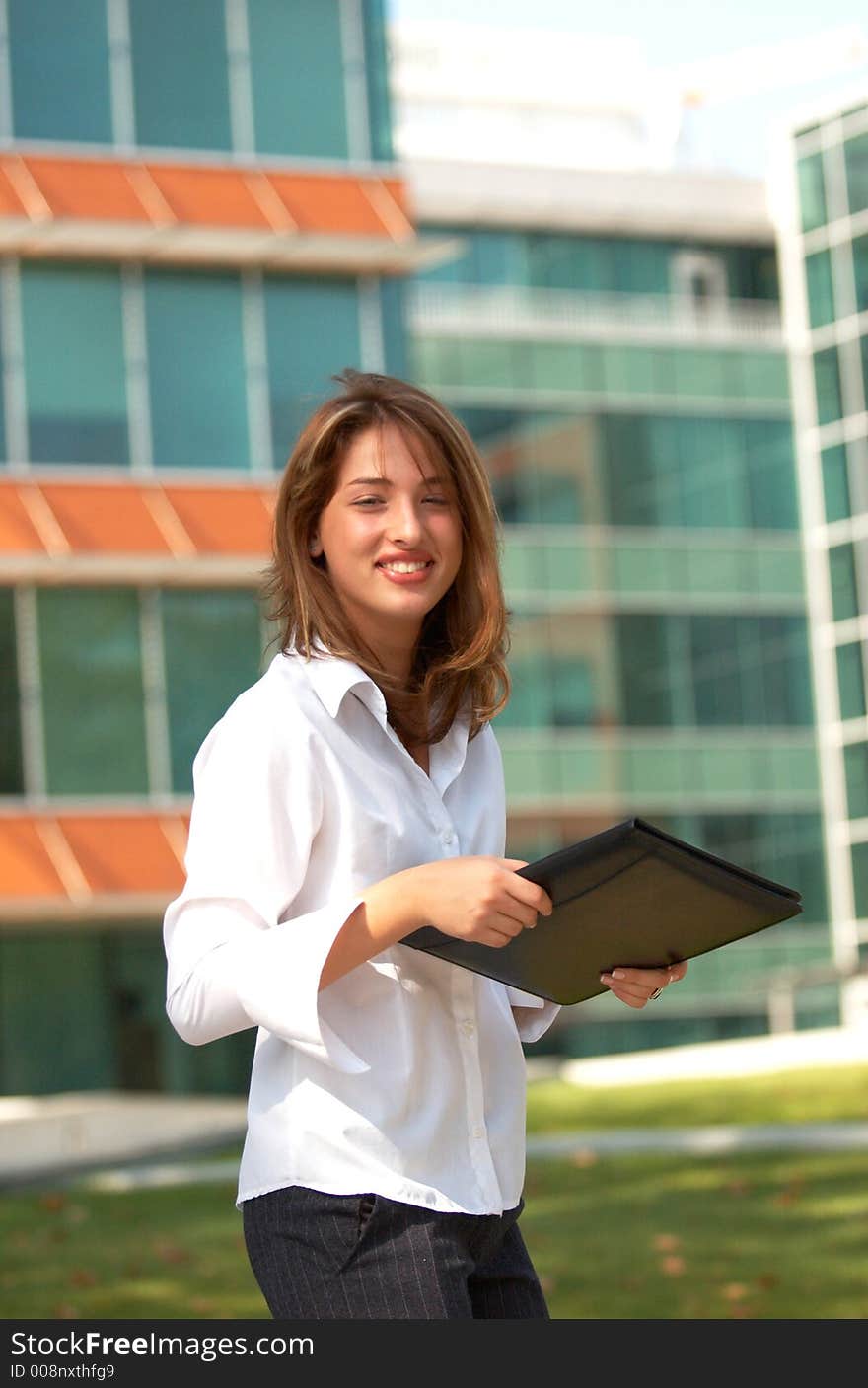 Portrait of a beautiful young girl with casual clothes holding an agenda in her hands, smiling and looking relaxed. Portrait of a beautiful young girl with casual clothes holding an agenda in her hands, smiling and looking relaxed