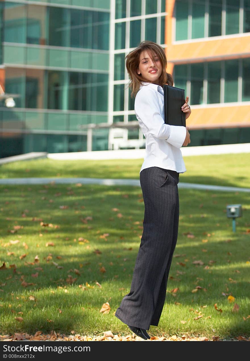 Portrait of a beautiful young girl with casual clothes holding an agenda in her hands, jumping and looking happy. Portrait of a beautiful young girl with casual clothes holding an agenda in her hands, jumping and looking happy