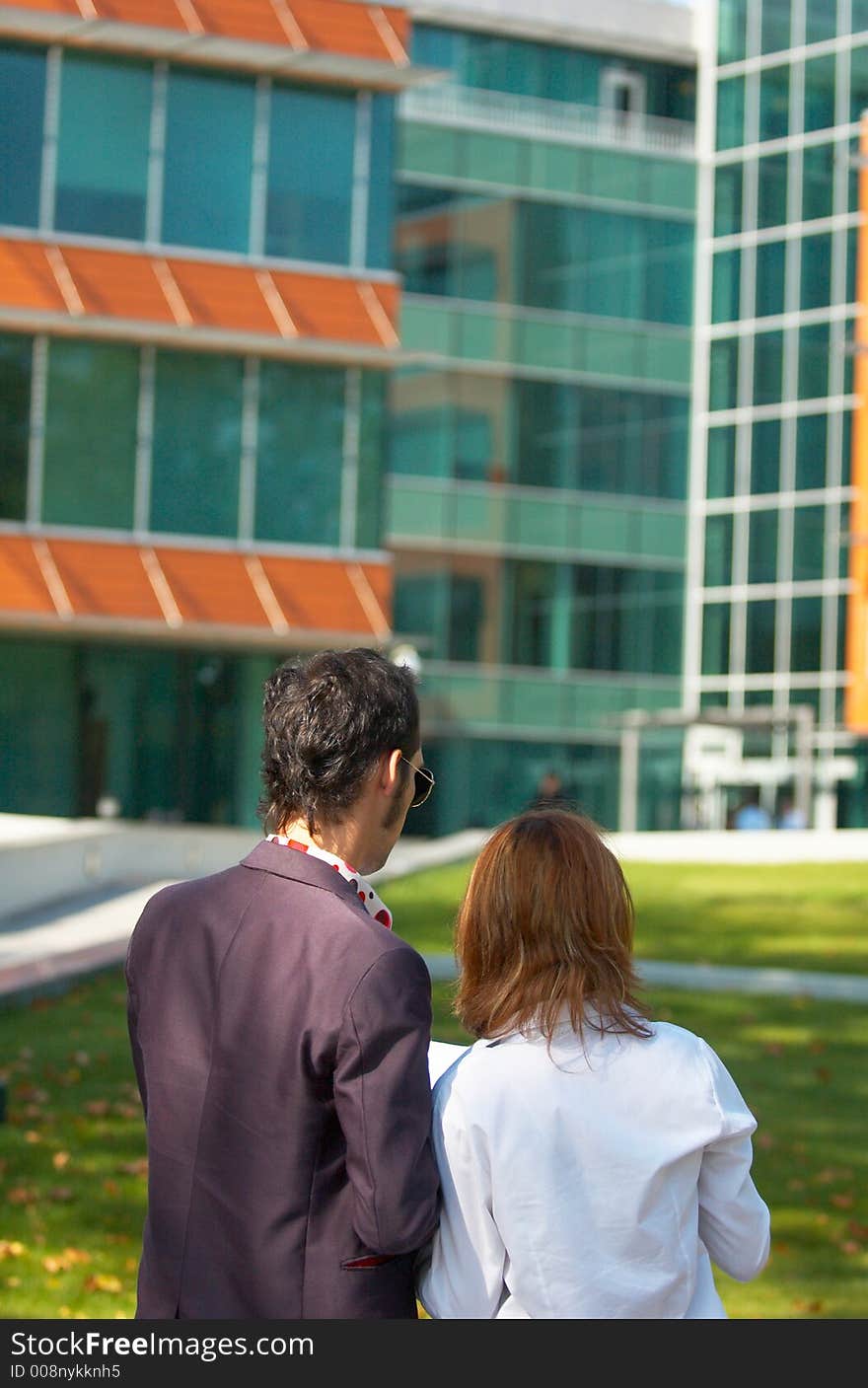 Young boy and girl checking some papers in front of an office building; business couple analising some documents. Young boy and girl checking some papers in front of an office building; business couple analising some documents