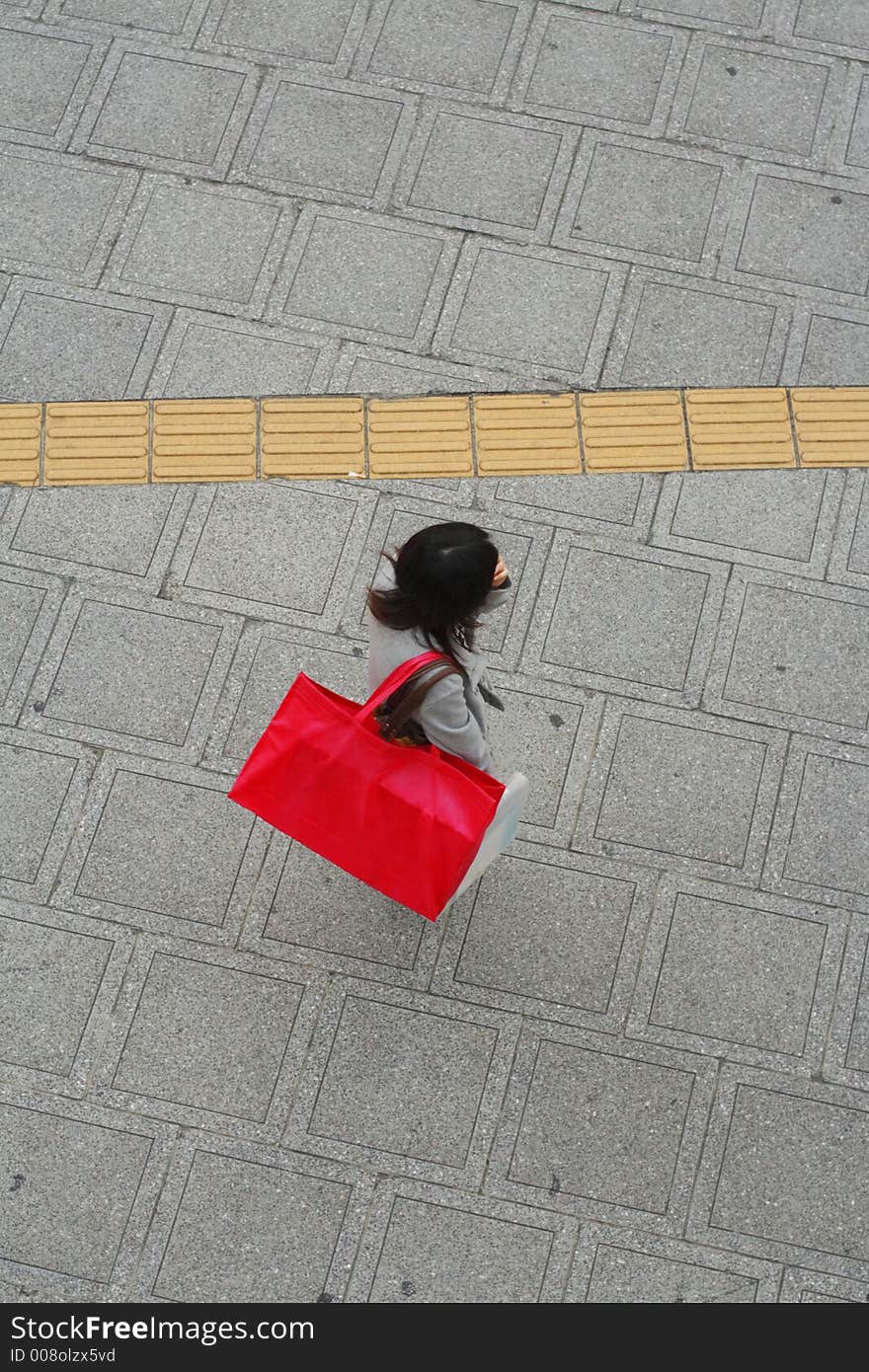 Woman with a big pink shopping bag in a city street-upper view. Woman with a big pink shopping bag in a city street-upper view