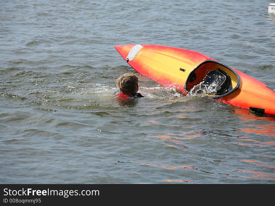 A lake in denmark with a boy falling out of a kayak. A lake in denmark with a boy falling out of a kayak