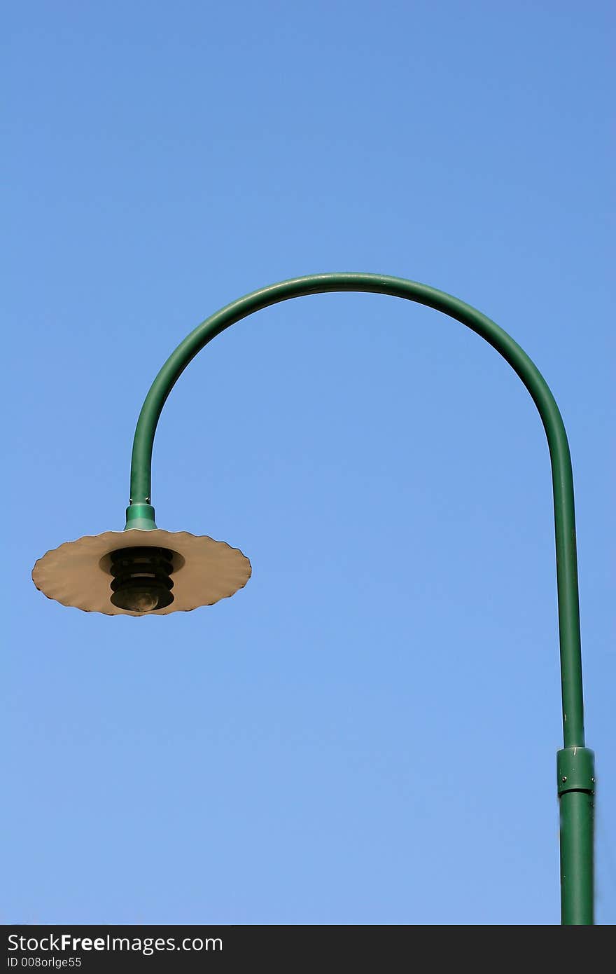 Green street light isolated against blue sky. Green street light isolated against blue sky