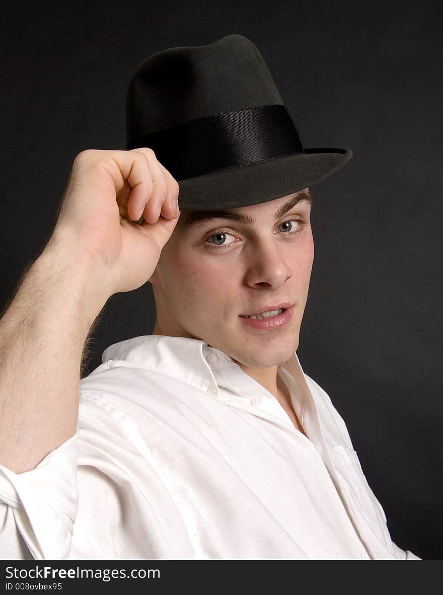 Handsome young man tipping his felt hat. Handsome young man tipping his felt hat