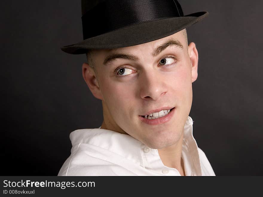 Handsome young man tipping his felt hat. Handsome young man tipping his felt hat