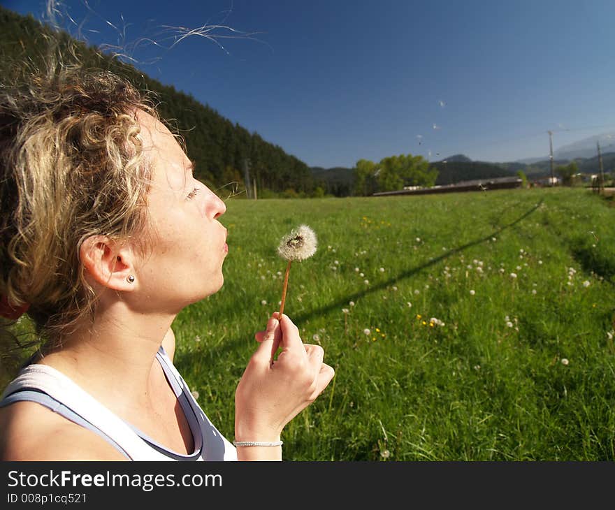 Girl Blowing Seeds Out Of A Dandelion