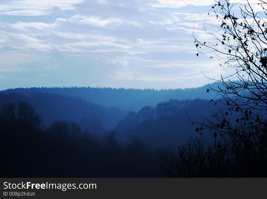 Cold blue winter landscape in woodeed valley