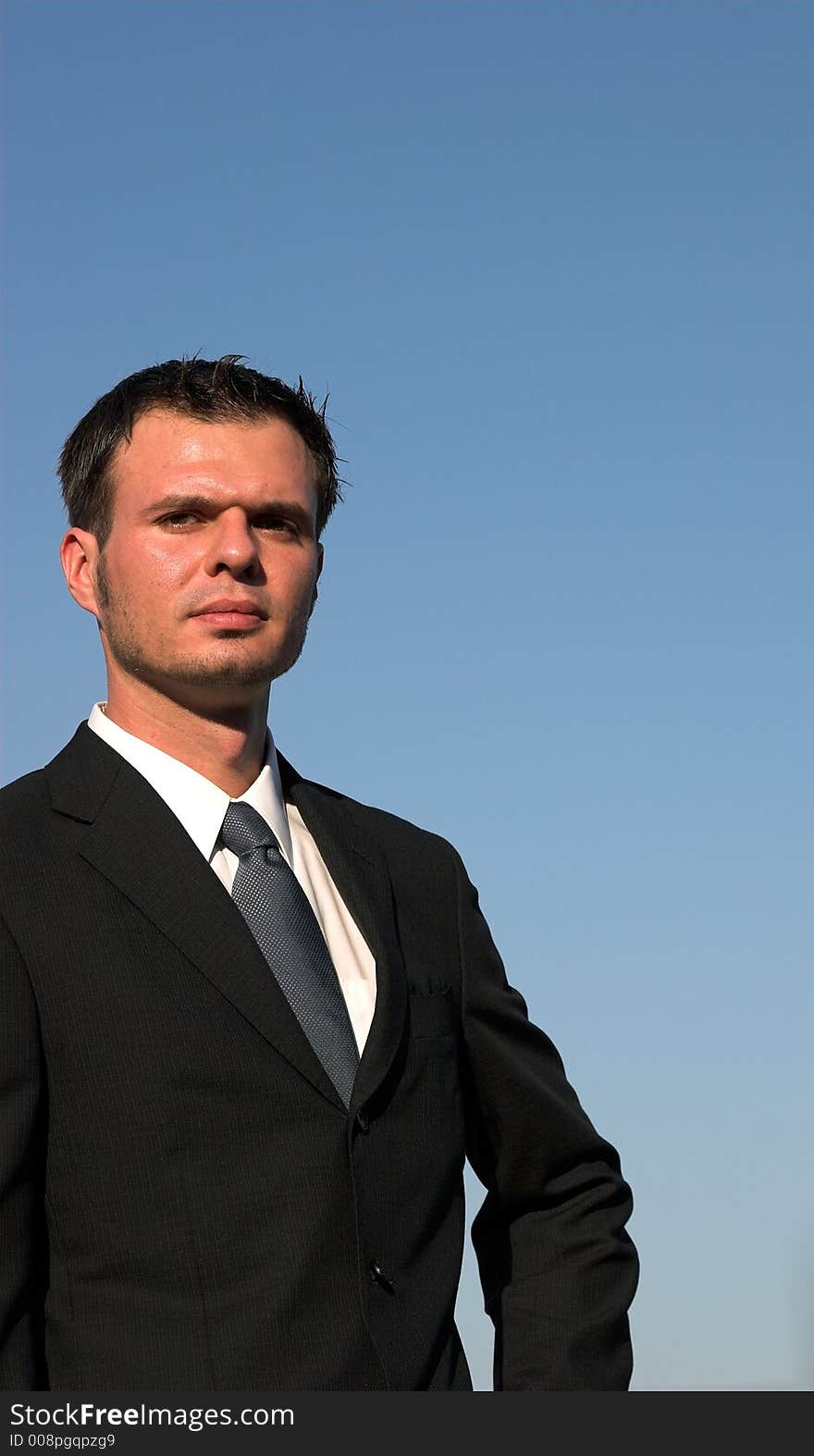 Young businessman with a blue sky behind him. Young businessman with a blue sky behind him.