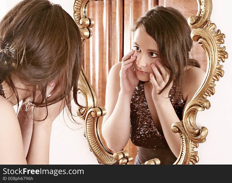 Auburn-haired girl, young woman putting make up in front of a mirror