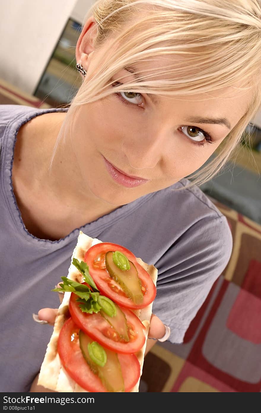 Woman eating a tomato sandwich