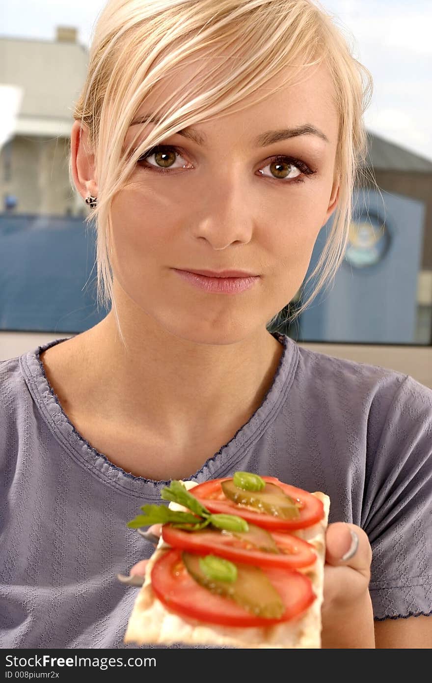 Woman eating a tomato sandwich