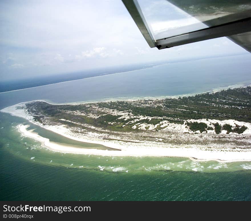 This is the north end of the St. Joseph Peninsula showing the old beaches which reach as much as thirty feet in height.  It is the northern extension of the Cape San Blas and the view is to the east towards the town of Saint Joe Beach.  Part of the plane wing and window are in view. This is the north end of the St. Joseph Peninsula showing the old beaches which reach as much as thirty feet in height.  It is the northern extension of the Cape San Blas and the view is to the east towards the town of Saint Joe Beach.  Part of the plane wing and window are in view.