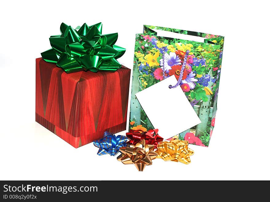 Christmas boxed gift with a ribbon and a gift bag with bow ribbons isolated on white with a gift card to put your message on. Christmas boxed gift with a ribbon and a gift bag with bow ribbons isolated on white with a gift card to put your message on