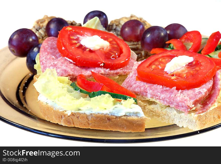 Sandwich and grapes on plate on white background. Sandwich and grapes on plate on white background