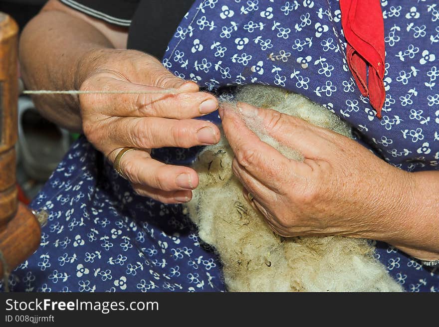 Hands of an old craftswoman, spinning wool. Hands of an old craftswoman, spinning wool