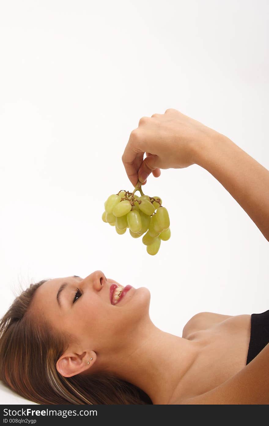 A girl smiles, after her workout, at some fresh green grapes that she knows she's going to enjoy. A girl smiles, after her workout, at some fresh green grapes that she knows she's going to enjoy.