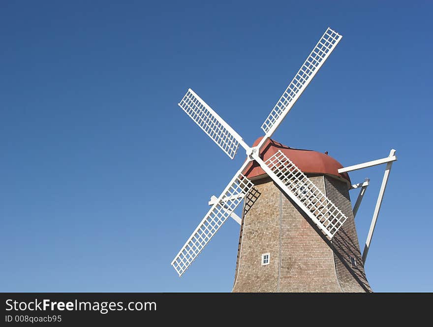 A vintage dutch wind mill with white blades. A vintage dutch wind mill with white blades.