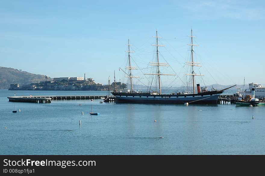 Alcatraz Island and sailing ship in the foreground with calm sea. Alcatraz Island and sailing ship in the foreground with calm sea