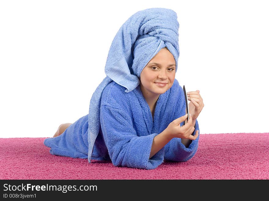 Young woman dressed blue bathrobe and towel filing nails