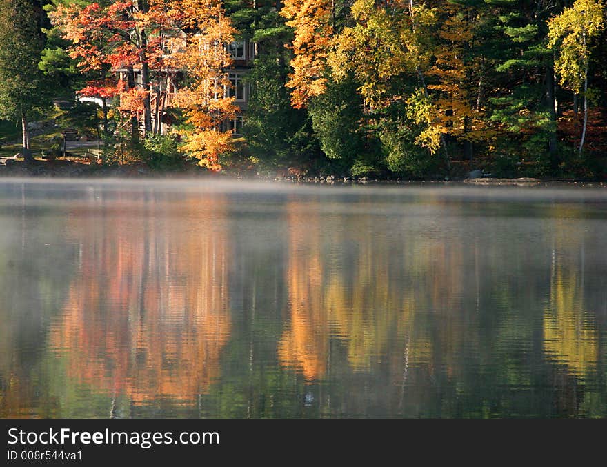 Autumn lake reflection in the Muskoka region of Canada with brilliant colors