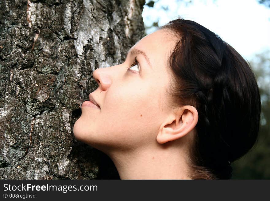 Portrait of a young woman leans on a tree. Portrait of a young woman leans on a tree