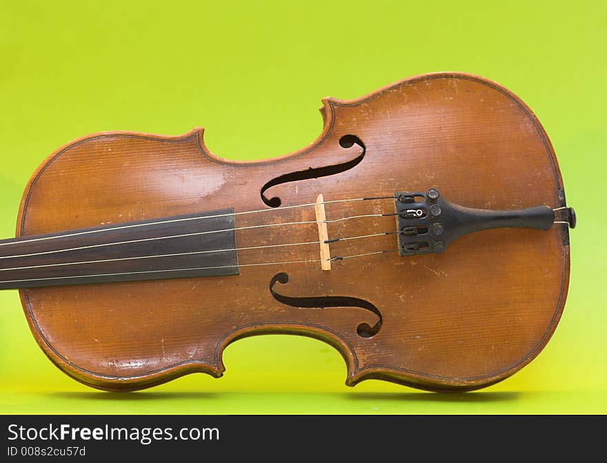 Old violin with shadows (not isolation) on a green background