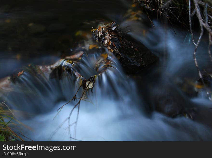 A small stream in autumn, full of leaves and branches, shoot with slow shutterspeed to get a sense of movement to the water,. A small stream in autumn, full of leaves and branches, shoot with slow shutterspeed to get a sense of movement to the water,